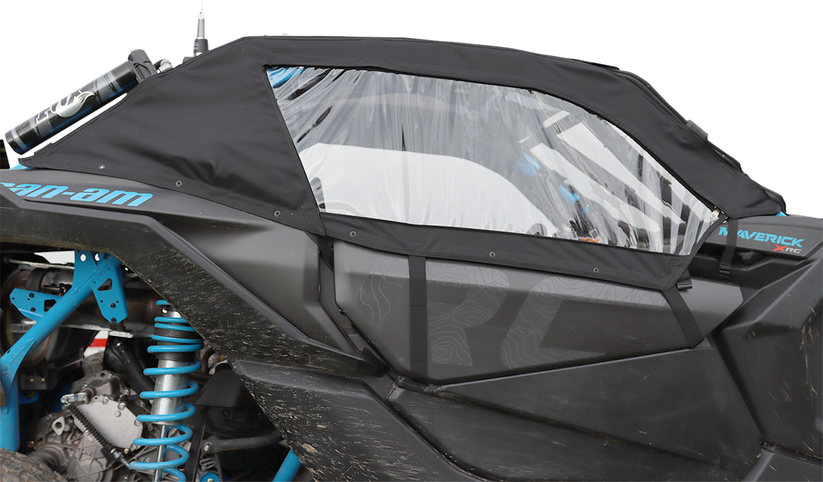 A black soft cab enclosure with a clear plastic window covers the side of a blue Can-Am Maverick X3 off-road vehicle, protecting the interior while still showing the suspension and mud on the lower panels.