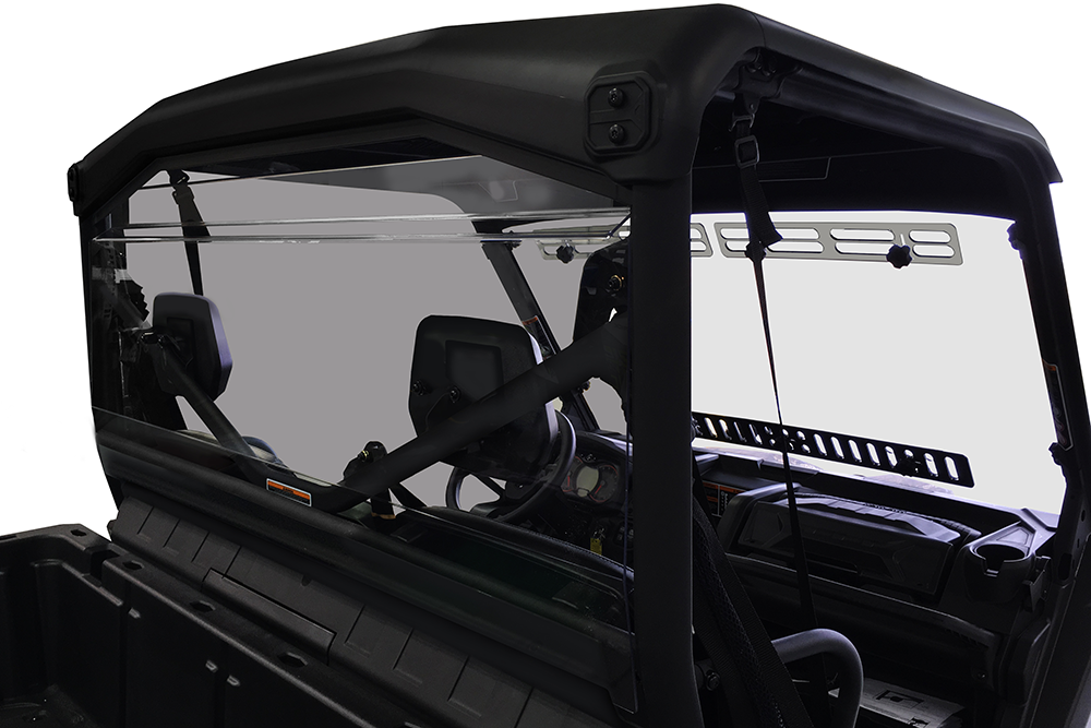A close-up of the Can Am Defender Rear Windshield-Gp (New Style W/Notch)-Tinted 2016+, installed on a black utility vehicle, shows two seats, steering wheel, dashboard, and roll cage; exterior is obscured against a white backdrop.