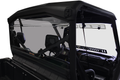 A close-up of the Can Am Defender Rear Windshield-Gp (New Style W/Notch)-Tinted 2016+, installed on a black utility vehicle, shows two seats, steering wheel, dashboard, and roll cage; exterior is obscured against a white backdrop.