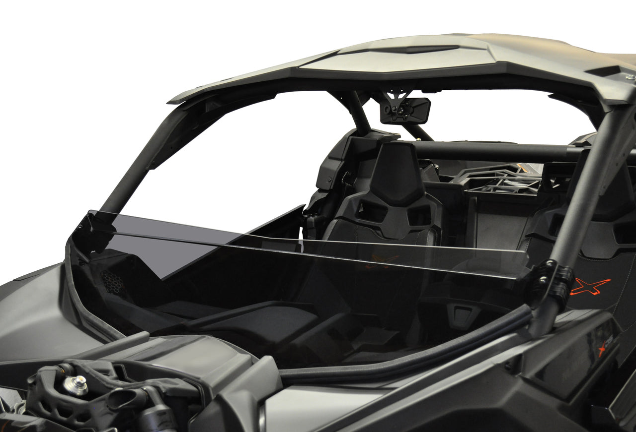 A close-up of a Can Am Maverick X-3 (2017+) off-road vehicle in black, featuring two bucket seats, steering wheel, and a dark tint short shield-GP at the front. The rugged design and angular roof stand out against the plain white background.