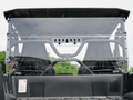 A Yamaha Wolverine X-2 Rear Windshield-Vented-Gp is installed on a black 2019-20 Wolverine X-2 utility vehicle, revealing two black bucket seats inside with green trees and a cloudy sky visible through the clear rear windshield.