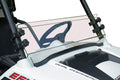 A Polaris Rzr 570/800/900 Short Shield-Hard Coated Scratch Resistant windshield is mounted on an off-road vehicle, attached with black brackets. The steering wheel and dashboard are visible behind the shield; background is plain white.