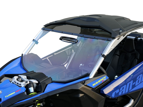 A close-up of a blue Can-Am Maverick X-3 with a Multi-Vents Hard Coat Scratch Resistant Windshield (2017+) shows the front windshield, black roof, and two-seat interior. Frame and dashboard details stand out against a white background.
