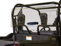 A close-up of a Honda Pioneer 700 Rear Vented Windshield installed on a black utility vehicle shows two headrests, interior safety netting, the Pioneer logo, and a visible safety label.