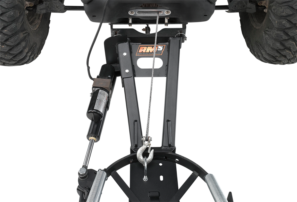 Close-up view of an ATV snow plow mount system attached under a vehicle, featuring a black metal frame, winch cable, hydraulic shock, springs, and an RM3 logo on the central bracket. The image is shot from below, showing the vehicle’s large tires.
