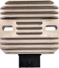 A rectangular, metal device with horizontal ridges and two oval slots on each side. A black plastic connector protrudes from the bottom center. The overall appearance suggests its an electronic or automotive component, possibly a heat sink or regulator.