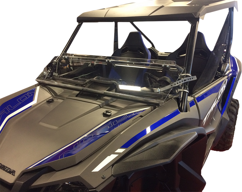 A black and blue off-road side-by-side vehicle with a transparent folding windshield and two bucket seats. The vehicle has angular, rugged features, a roof, and is photographed from the front left side against a white background.