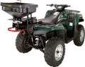 A green Kawasaki four-wheeler ATV is shown with large, rugged tires. Mounted on the rear rack is a black MOOSE brand seed or salt spreader with a hopper and spinning mechanism, attached securely to the vehicle.