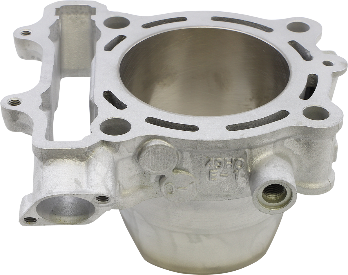 A close-up view of a machined metal engine cylinder component with a large circular opening, multiple smaller holes, smooth silver surface, and various protrusions, grooves, and threaded port, set against a plain white background.