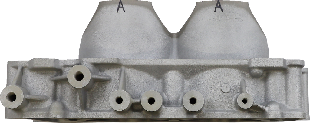 A close-up view of a metallic engine cylinder head, shown from the side. The surface has multiple round openings and protrusions, with two large domed sections marked with the letter A on top. The metal is unfinished, giving it a rough texture.