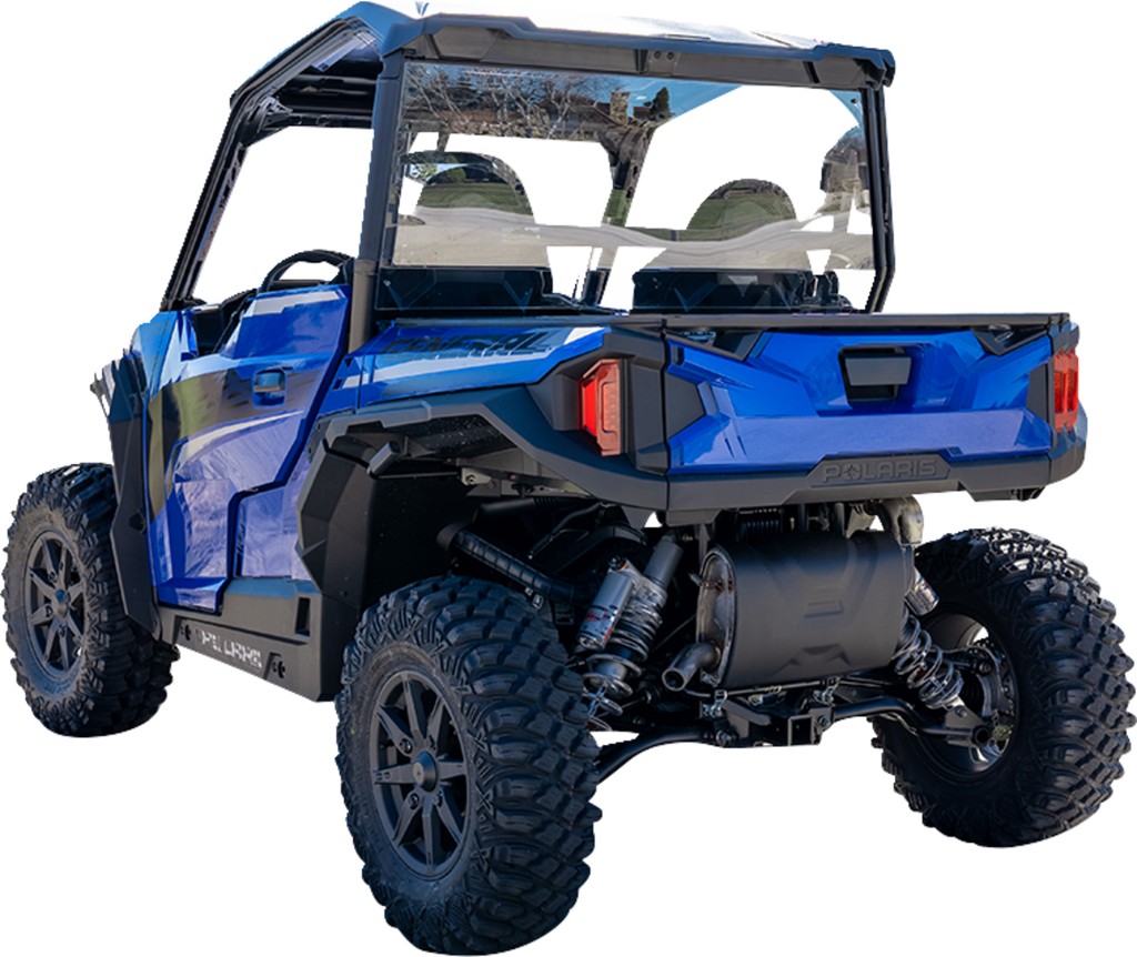 A blue Polaris off-road utility vehicle with rugged tires, black roof, and rear cargo area is shown from a rear angled view. The suspension and undercarriage are visible, and two seats with seatbelts are seen inside through the clear rear window.