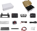 An assortment of vehicle electronic kit components arranged neatly: two white boxes (one open with foam inserts), metal brackets, a switch panel, wiring, a breaker, zip ties, small screws, cable labels, and mounting hardware, all displayed on a white back