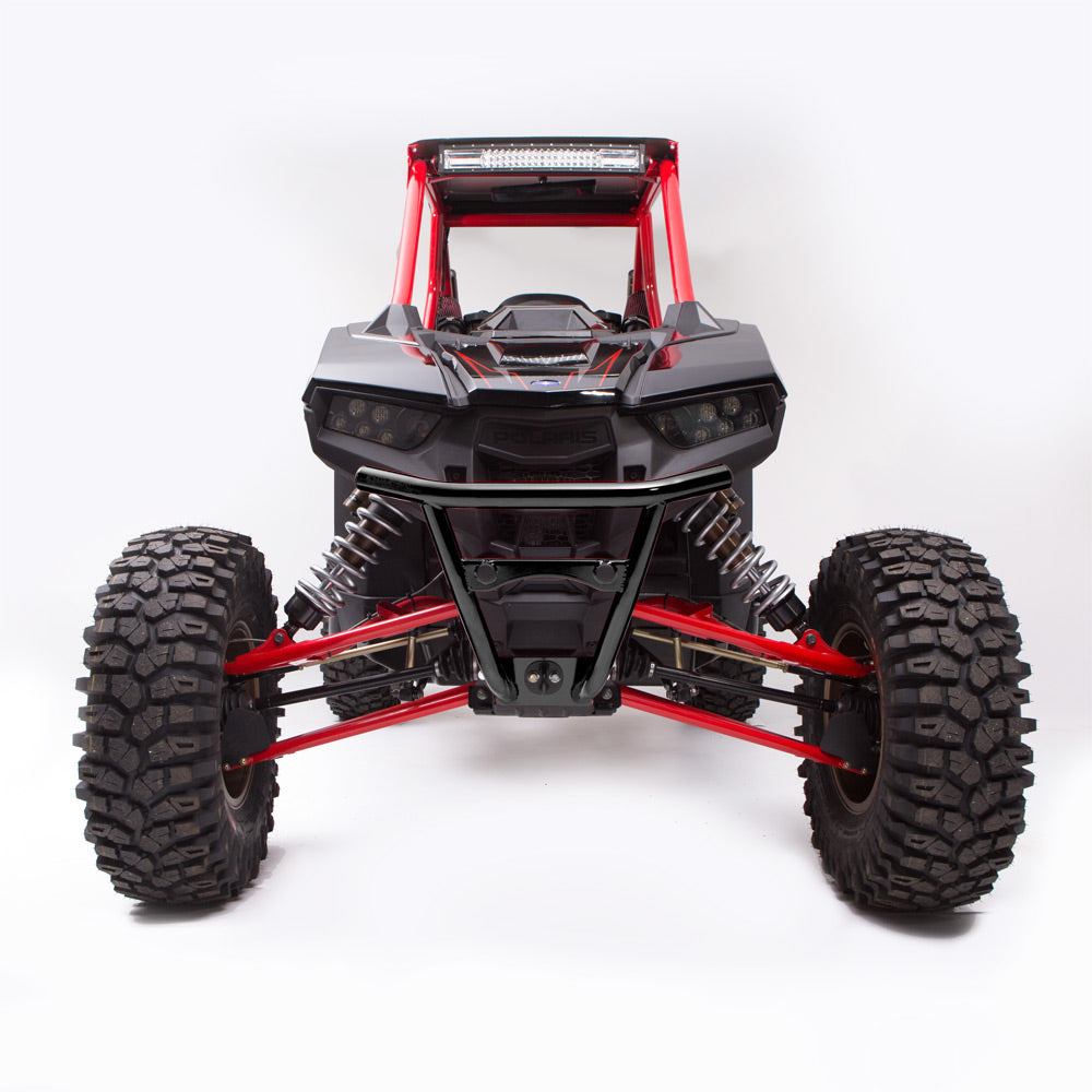 Front view of a Polaris Rzr Rs1 Hmf Defender Front Lt Bumper (2018+), featuring large rugged tires, visible suspension springs, a protective roll cage, and a black frame with red accents, set against a clean white background.