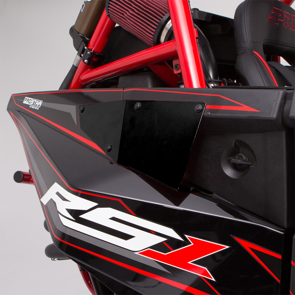 Close-up of a Polaris Rzr RS1 HMF Radiator Scoop (2018+) panel in black and red with bold RS1 lettering. Visible features include red chassis bars, air filter, vehicle seat, and partial ProStar branding in the background.