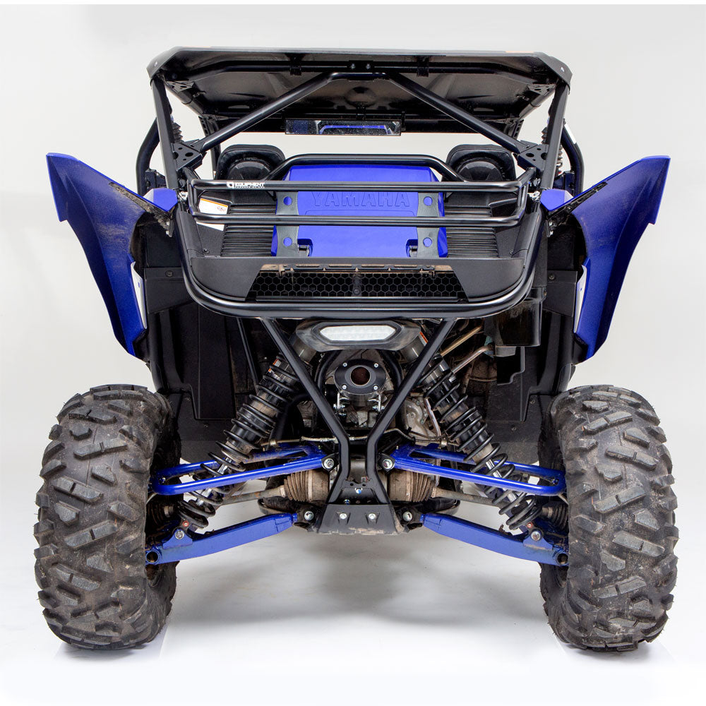 A Yamaha YXZ 1000R with a black HMF Cargo Rack (2019+) seen from the rear, featuring big rugged tires, visible suspension springs, a strong roll cage, and exposed mechanical parts for tough off-road use.