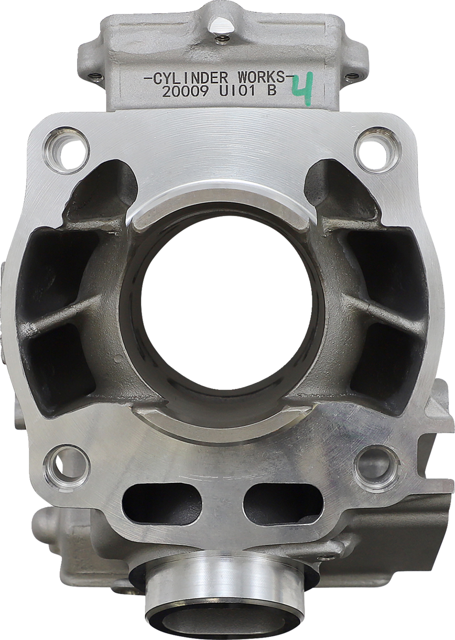 Close-up view of a metal engine cylinder with a large central bore, visible side ports, and detailed machined surfaces. The top is labeled “CYLINDER WORKS 20009 U101 B 4” in black and green text. The background is plain white.