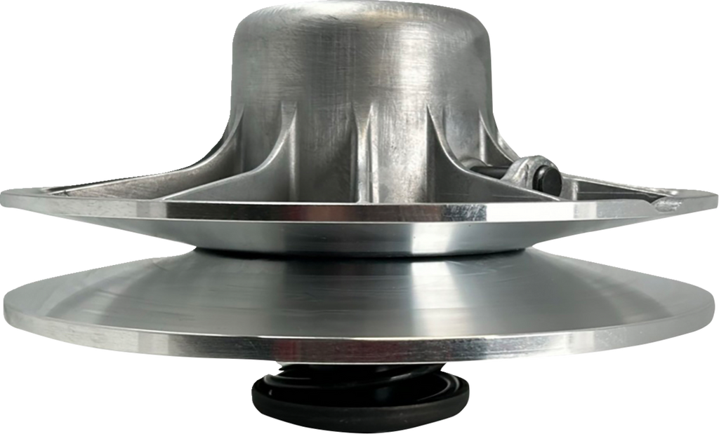A close-up side view of a shiny, metallic mechanical pulley with a wide, flat base and a domed top, featuring radial spokes and bolts. The lower half has a smooth, circular plate connected to a small black spring at the bottom.