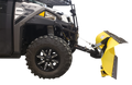 A close-up side view of an off-road utility vehicle with rugged black tires, featuring a large, curved yellow snow plow attachment mounted to its front. The plow is angled and has a black edge for scraping, with metal supports connecting it to the vehicle