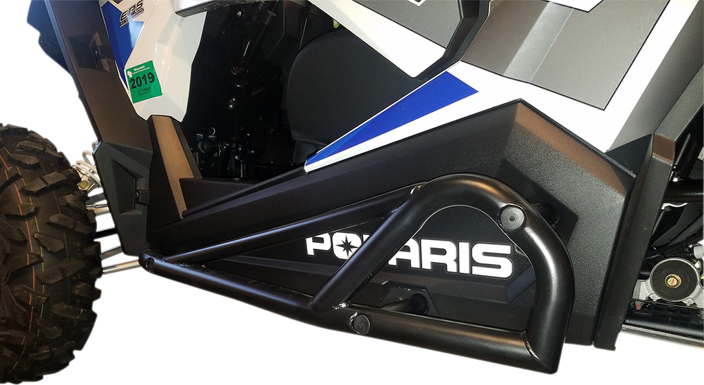 Close-up of a black off-road vehicle’s side, showing a tubular nerf bar and the word “POLARIS” in bold white letters. Part of a tire, the door panel, and blue, white, and gray graphics are visible, along with a green registration sticker.