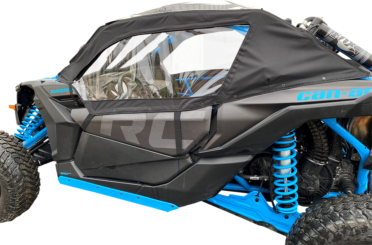 A close-up side view of a black and blue off-road vehicle with large rugged tires, blue suspension springs, and a transparent plastic window in a black fabric door cover. The word “Can-am” is visible along the top edge of the door.