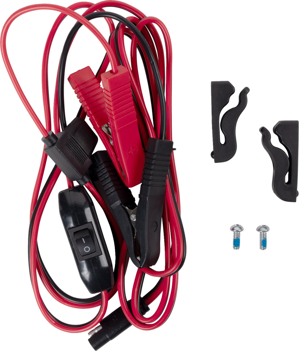 A coiled set of red and black jumper cables with alligator clips, a black inline switch, and a connector. Next to the cables are two black plastic mounting brackets and two small metal screws on a plain white background.