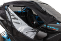 Close-up of a black, semi-open zippered soft door with a clear plastic window on a blue Maverick X RC off-road vehicle. The interior features black and blue accents, seat belts, and a roll cage, visible through the clear panel.