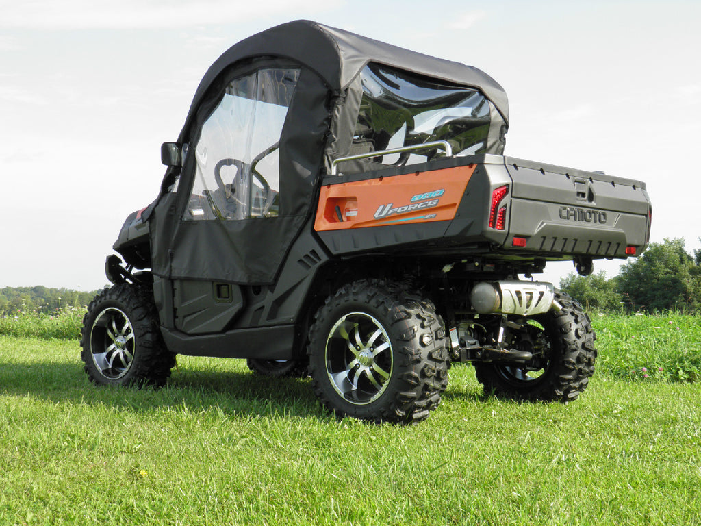 A Cf Moto Uforce 500/800 with Soft Doors and Rear Window Combo for an existing hard windshield and top is shown in black and orange, parked on grass with clear side windows, rear cover, trees, and blue sky in the background.
