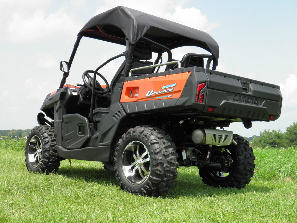 A rugged orange and black side-by-side utility vehicle with large off-road tires is parked on green grass under a partly cloudy sky. The vehicle features a Cf Moto Uforce 500/800 Soft Top, roof, roll bars, and Chironex rear tailgate.