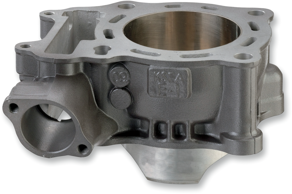 A close-up image of a gray metal engine cylinder block with smooth, machined surfaces, openings for pistons, and various mounting holes. The block features engraved markings and casting details, and its internal cylindrical chamber is clearly visible.