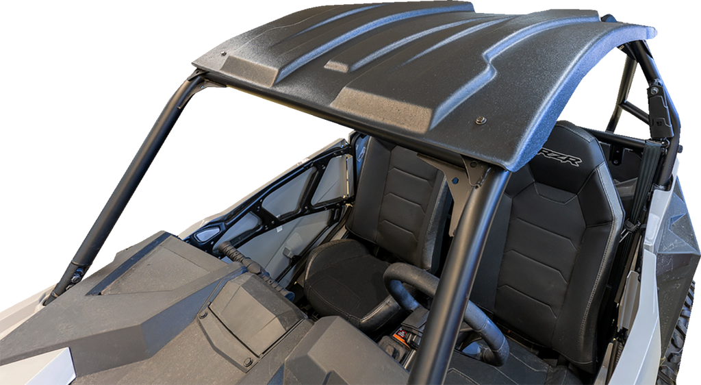 A black, rugged roof attaches to the roll cage of an off-road side-by-side vehicle. The image shows two black bucket seats, a steering wheel, and part of the dashboard, all under the sturdy roof with angular contours. The background is plain white.