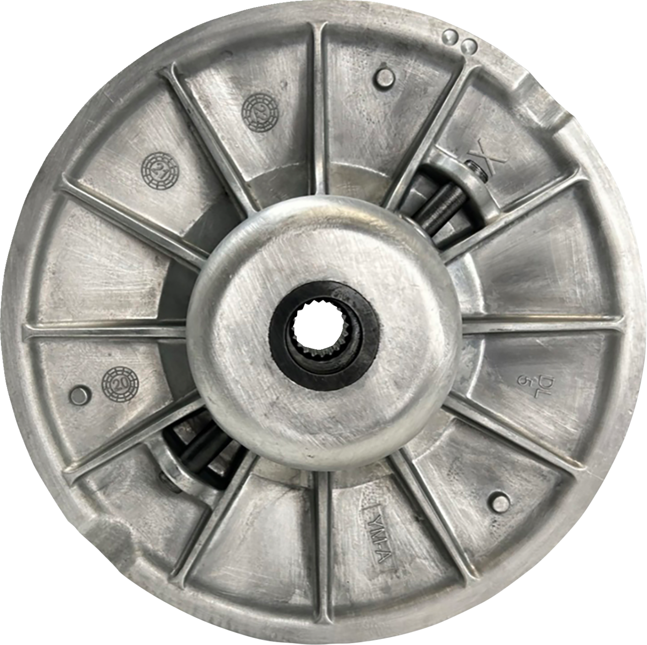 A close-up of a round, metallic mechanical part with radial supports, a central hole containing gear teeth, and engraved markings. The surface shows a matte finish and features various symbols and numbers, suggesting it’s a component of a machine or vehic