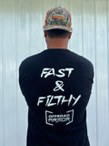 A bearded person faces away, wearing a Fast and Filthy - Offroad Armor Next Level T-Shirt with bold white “FAST & FILTHY” and “OFFROAD ARMOR” text, plus a camo hat featuring the OFFROAD ARMOR logo, against a white metal wall.