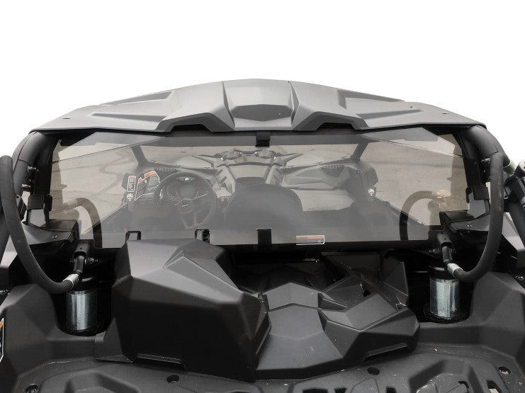 Rear view of a black off-road vehicle fitted with the Can-Am Maverick X3 Tinted Polycarbonate Rear Window. The open cargo bed, roll bars, visible shocks, and interior details like the steering wheel appear against a plain white background.