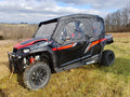 A Polaris General 4 with Offroad Armors Soft Doors Kit is parked on dry grass in a rural field. The side-by-side features large off-road tires, visible roll bars, and clear enclosures, with trees and cloudy skies in the background.