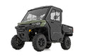 A green and black 2 Seater Can-Am Defender HD 5/HD 7/HD 8/HD 9/HD 10 with doors, large knobby tires, enclosed cabin, windshield, cargo bed, and side doors is shown front-side view on a white background.
