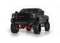 A black GMC 2500 truck (2015-2019) features the Identity Front Bumper Full Kit with wide end pods, shackle, X3 cube light pods, accent lights, and ring—all in black—seen from the front to highlight its aggressive, rugged style.