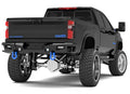 A lifted black Chevy Silverado 2500 features a 2020-2023 Identity Rear Bumper with Shackles End Pods, dual pod and single row light pods, beauty ring, HDWR kit, large off-road tires, blue tow hooks, and bold Silverado branding on the tailgate.