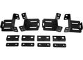 The 2005+ Nissan Frontier Treck Drill-Less Rack Base Mounting Bracket Kit (Mid-Size Trucks) - Texture Black includes four black metal brackets with multiple holes and slots, and six matching rectangular mounting plates, all displayed on a white background