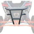 The Rear Bumper Polaris RZR Pro R in black metal with angular bars is shown over the rear of an orange off-road vehicle, highlighting mounting points alongside large suspension springs and prominent taillights.