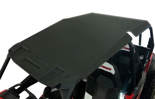 A close-up of a Polaris Rzr 4 900/1000 ABS Plastic Hard Roof (2014+ Rzr 1000, 2015+ Rzr 900) on an off-road vehicle with black and white bucket seats featuring red logo detailing. The roof is flat with angled edges.