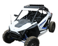 A Roof Rack Kit for the Polaris RZR XP Pro 2 Seater, designed for rough terrain, fits white off-road side-by-sides with muddy tires, open frame, roll cage, black roof rack, blue suspension springs, and RZR decals.
