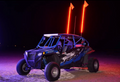 A blue and black off-road dune buggy sits on sand at night, featuring large rugged tires, a roll cage, roof LED light bar, and two glowing Bent Metal Led Whips extending from the rear against the dark sky.
