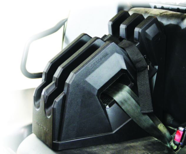 The Seizmik Cab On Seat Gun Holder, shown in black plastic on a light-colored car seat with metal armrest, features slots to organize and secure multiple seatbelt tongues, keeping them untangled and easily accessible.