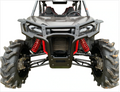 A front view of the Honda Talon with large, mud-covered tires, red suspension springs, and a rugged black Honda Talon Front Bumper. Two bucket seats and harnesses are visible in the open-top cabin against a white background.