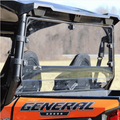 A close-up of the rear side of an orange off-road vehicle with GENERAL written on it, featuring two black seats and a Seizmik Rear Windshield. The clear windshield shows a blurred outdoor scene with grass and trees in the background.
