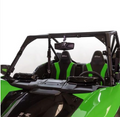 A close-up of a 2020+ Kawasaki KRX 1000 Versa-Vent Hard Coated Front Windshield, highlighting its fit in the green and black off-road vehicle’s interior with bucket seats, roll cage, steering wheel, dashboard, and rear-view mirror.