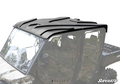 A Can-Am Defender Max Plastic Roof in black is mounted on a camouflage-patterned UTV with large windows. The image has a white background, the SuperATV logo in the bottom right corner, and some vehicle details are partially faded.