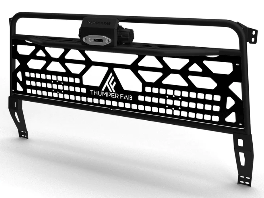 The 2016+ Can-Am Defender Winch Headache Rack (Black) features a rugged black metal design with geometric cutouts, angled side supports, a white THUMPER FAB logo at the center, and a top-mounted LED light bar for an industrial look.