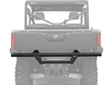 A Can-Am Defender HD5/HD7/HD8/HD9/HD10 Rear Bumper (all years) with angular lines and a center step plate is mounted on a UTV with large knobby tires, showing the rear cargo area, roll cage, and tail lights.