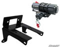 On the left is the Canam Commander 800 / 1000 Winch Mount, and on the right is a 2,500lb SuperATV winch with cable, hook, and red strap. Both are displayed on a white background with the SuperATV logo in the bottom right.